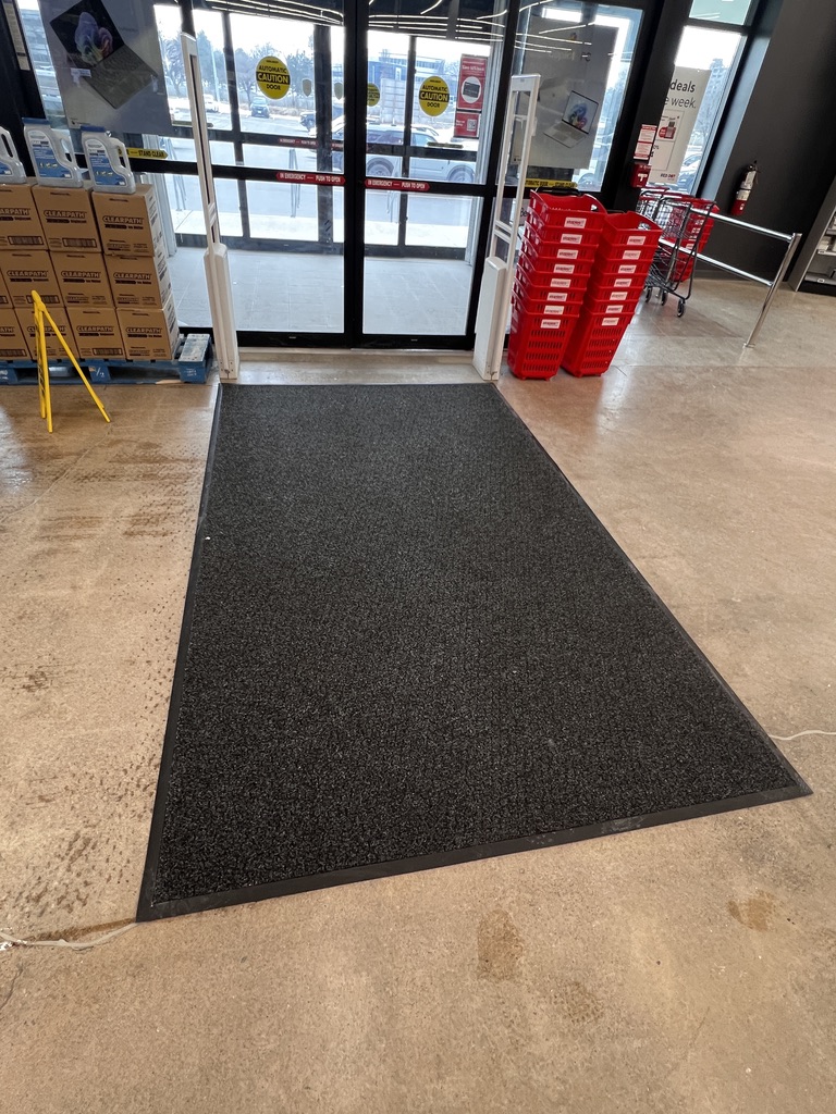 Clean commercial entrance carpet after professional washing, full entrance view