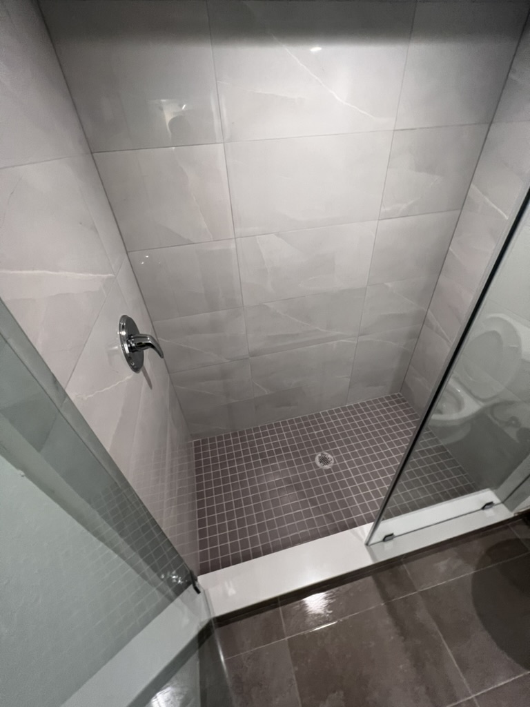 Detailed shower glass and tile after post-construction cleaning